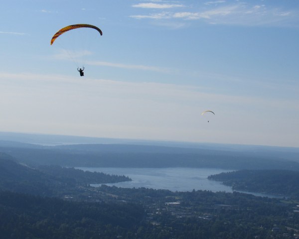 Two parasailers above a lake.